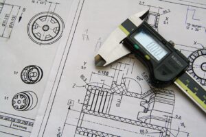 Detailed technical drawings on graph paper showcasing the design and dimensions of a mechanical device, featuring intricate lines and angles indicating various parts and their assembly